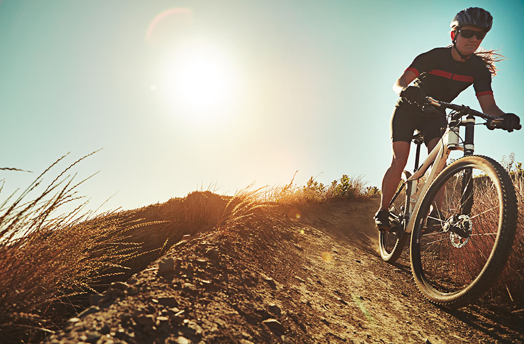 cyclist on a mountain bike riding down a dirt path towards the camera