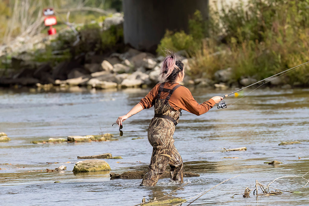 a young girl fishing for salmon in a river